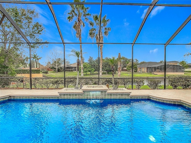 view of pool with pool water feature, glass enclosure, a patio area, and a grill