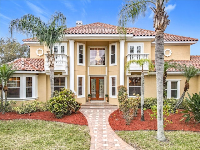 mediterranean / spanish-style home with french doors and a balcony