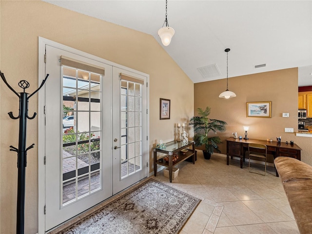 entryway featuring light tile patterned floors, french doors, and vaulted ceiling