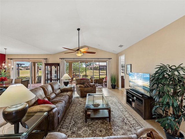 living room featuring light tile patterned floors, lofted ceiling, and ceiling fan with notable chandelier