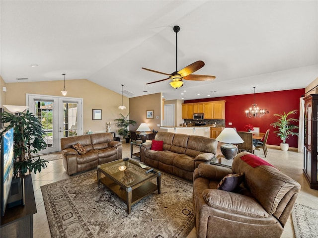 tiled living room with ceiling fan with notable chandelier, french doors, and vaulted ceiling