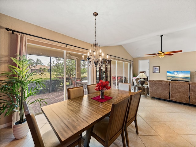 tiled dining space with lofted ceiling, a healthy amount of sunlight, and ceiling fan with notable chandelier