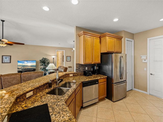 kitchen featuring light tile patterned floors, ceiling fan, stainless steel appliances, backsplash, and sink