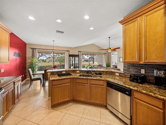 kitchen with ceiling fan with notable chandelier, dishwasher, decorative backsplash, sink, and vaulted ceiling