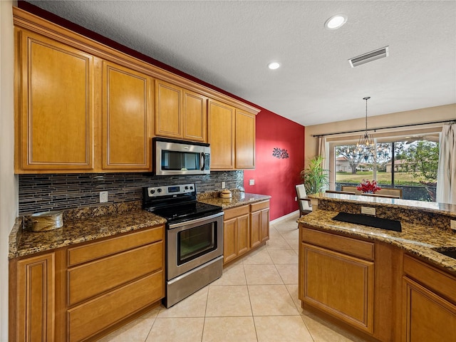 kitchen with pendant lighting, appliances with stainless steel finishes, dark stone countertops, tasteful backsplash, and an inviting chandelier