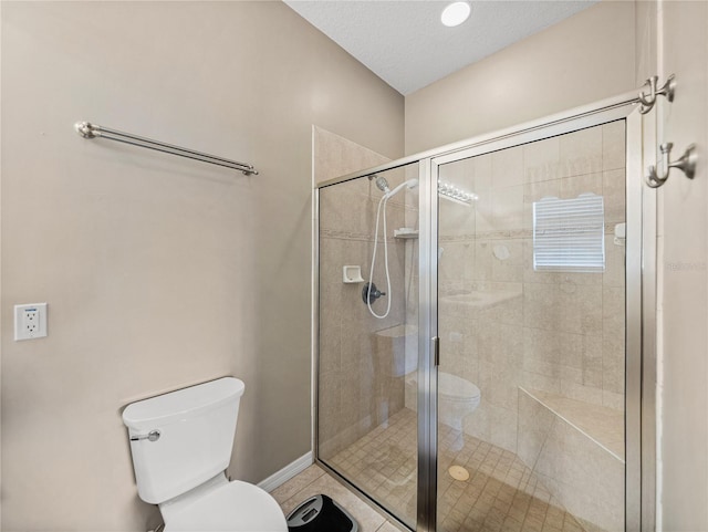 bathroom featuring toilet, tile patterned flooring, a textured ceiling, and walk in shower