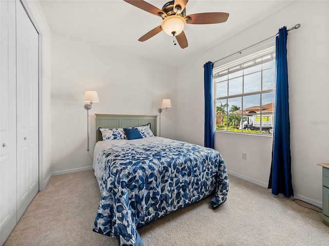 carpeted bedroom featuring ceiling fan and a closet