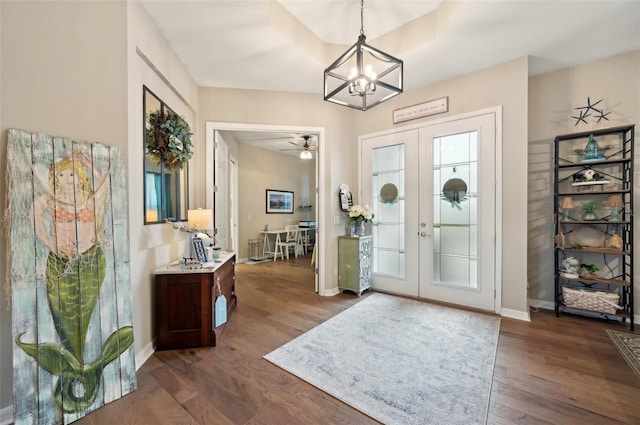 foyer entrance featuring french doors, dark wood-type flooring, and ceiling fan with notable chandelier