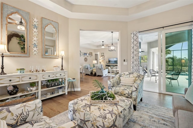 living room featuring hardwood / wood-style flooring and a raised ceiling