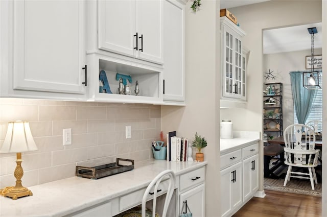 kitchen featuring pendant lighting, light stone countertops, white cabinetry, and tasteful backsplash