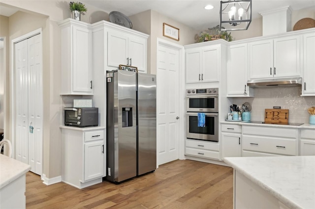 kitchen featuring decorative light fixtures, backsplash, an inviting chandelier, stainless steel appliances, and white cabinets