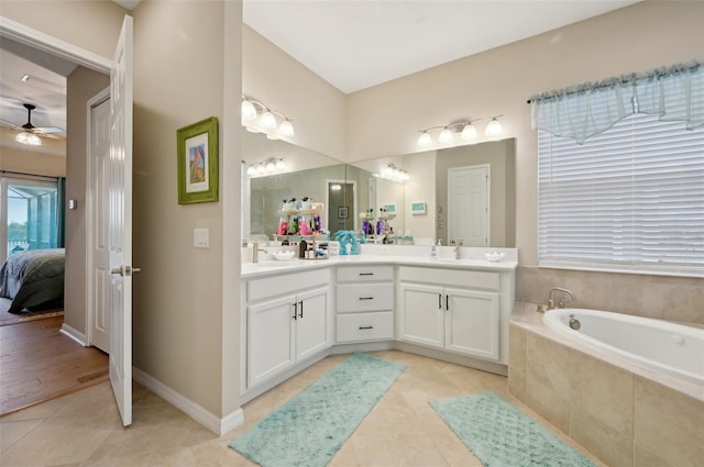 bathroom with ceiling fan, a relaxing tiled tub, tile patterned floors, and vanity