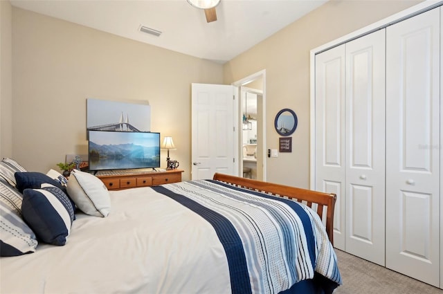 bedroom with ceiling fan, light colored carpet, and a closet