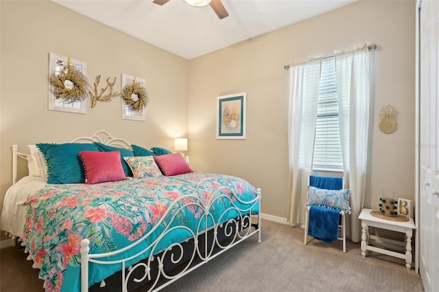 bedroom featuring ceiling fan, multiple windows, and carpet flooring