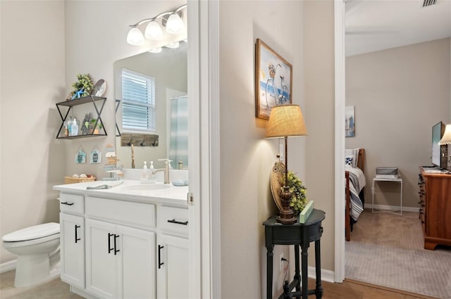 bathroom featuring toilet, vanity, and walk in shower