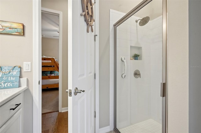 bathroom with walk in shower, vanity, and wood-type flooring