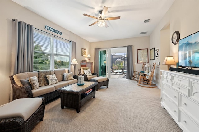 carpeted living room featuring ceiling fan and a healthy amount of sunlight