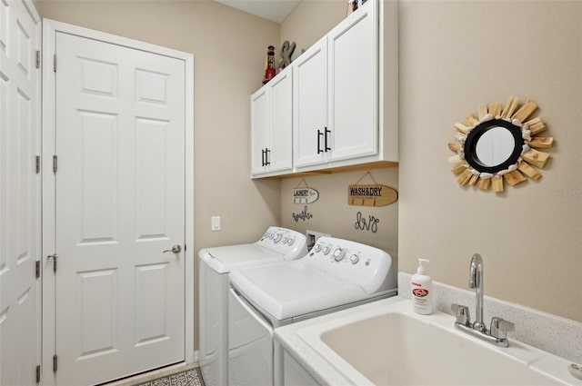 clothes washing area featuring cabinets, washer and dryer, and sink