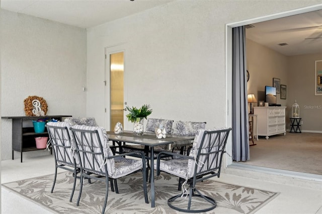 carpeted dining space featuring ceiling fan