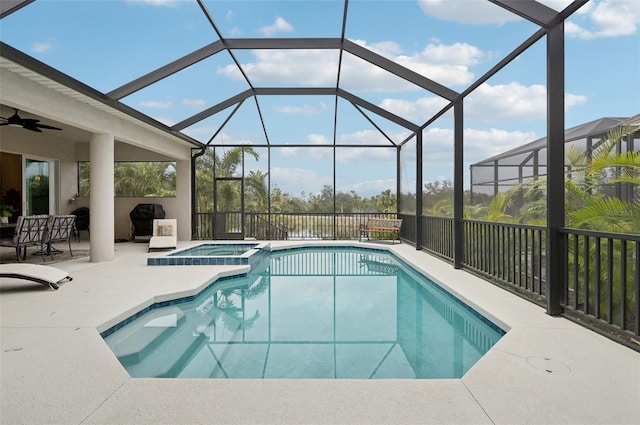 view of swimming pool with a patio area, glass enclosure, and an in ground hot tub