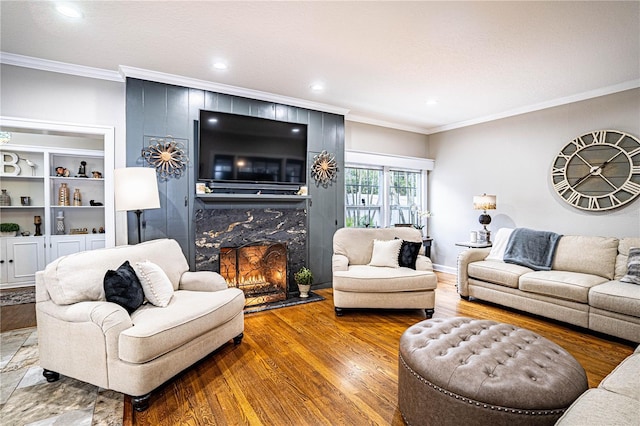 living room featuring a fireplace, ornamental molding, and hardwood / wood-style floors