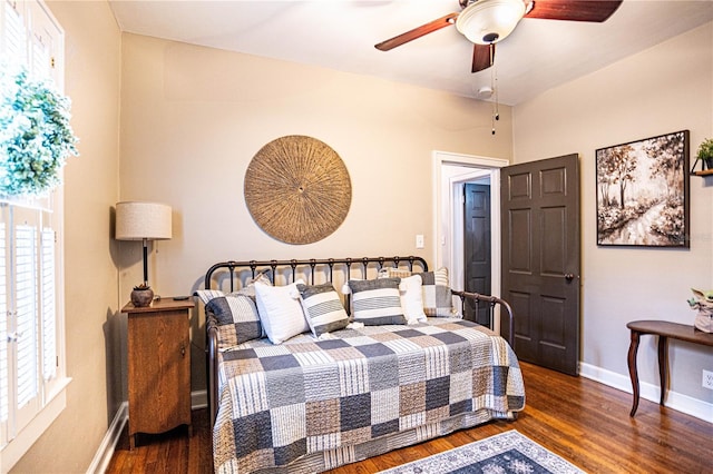 bedroom featuring ceiling fan, dark hardwood / wood-style floors, and multiple windows