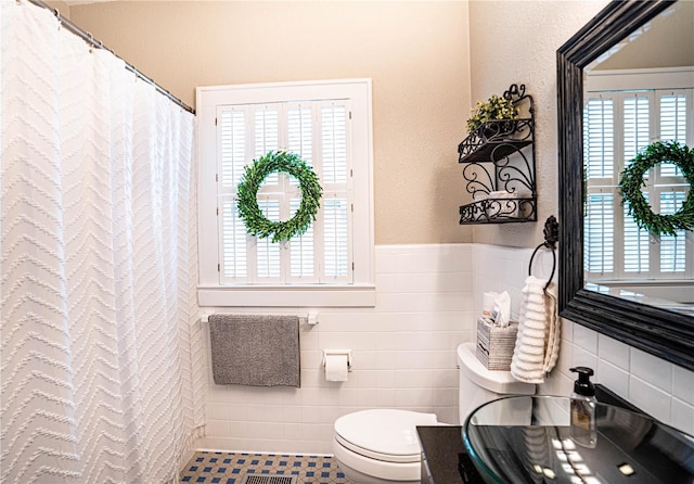 bathroom featuring tile walls, tile patterned floors, a shower with curtain, and toilet