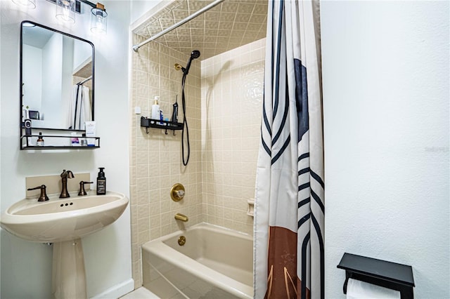 bathroom featuring shower / bathtub combination with curtain and sink