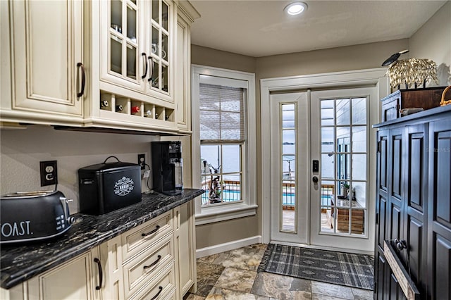 interior space featuring cream cabinetry and dark stone counters