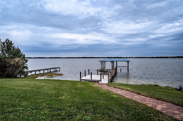 view of dock featuring a water view and a lawn