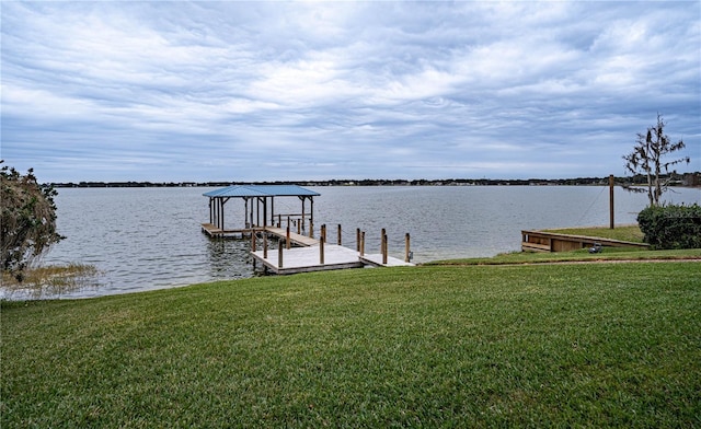 dock area with a lawn and a water view