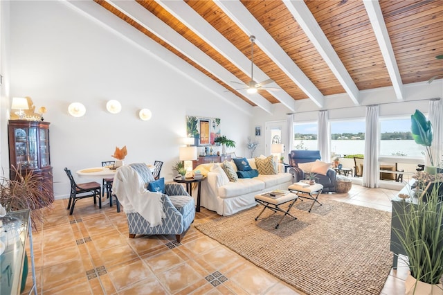 tiled living room featuring ceiling fan, beamed ceiling, a water view, and high vaulted ceiling