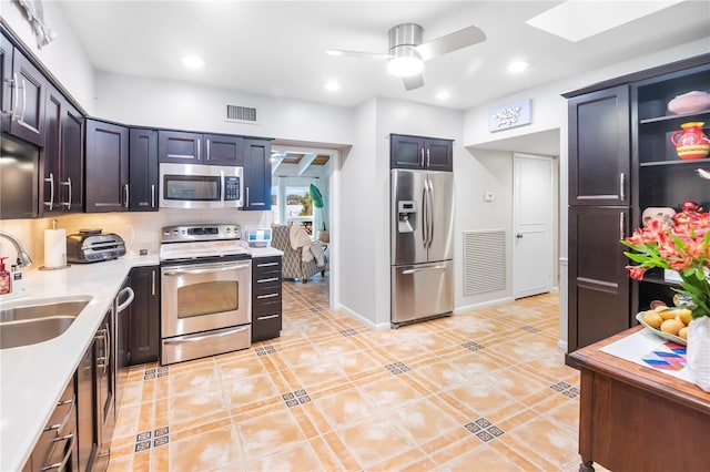 kitchen featuring ceiling fan, sink, appliances with stainless steel finishes, and light tile patterned flooring