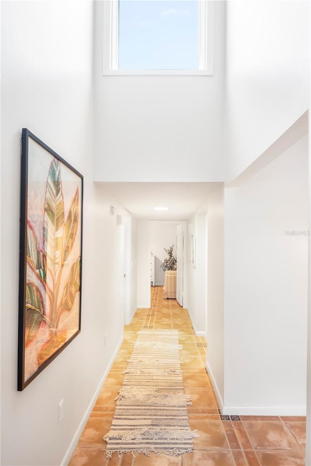 corridor featuring a wealth of natural light and a high ceiling