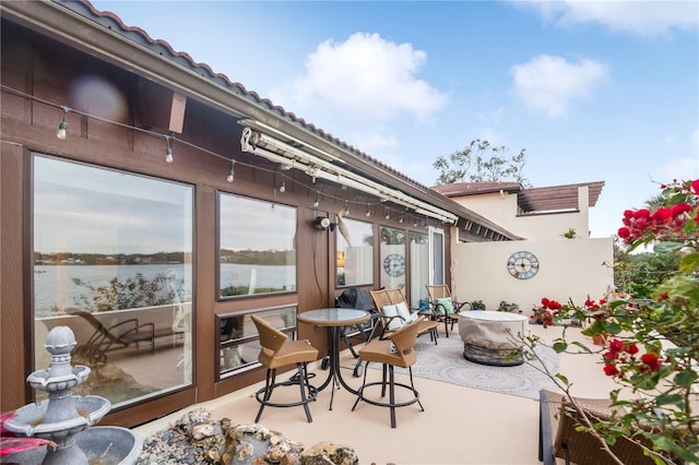 view of patio / terrace featuring a water view and a fire pit