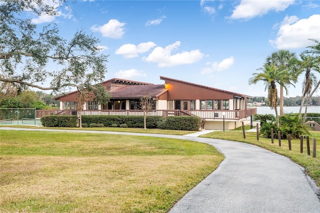 view of front facade featuring a front yard and a deck with water view