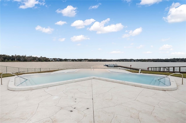 view of pool featuring a water view and a patio