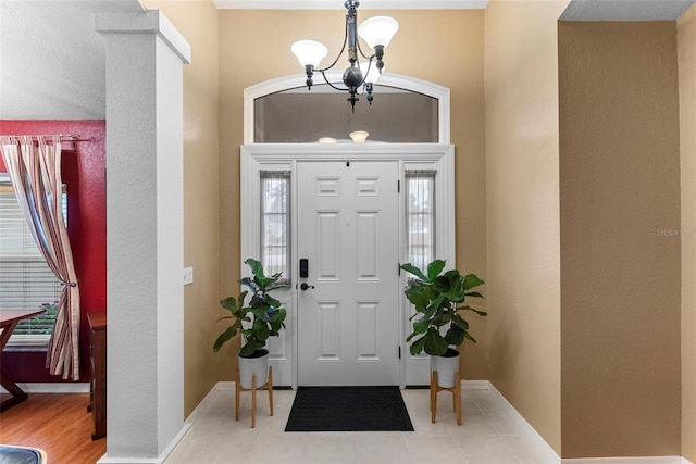 entrance foyer with light tile patterned floors and a notable chandelier