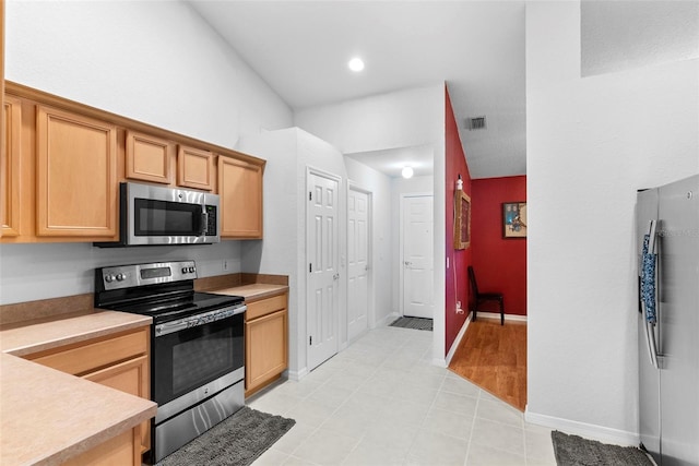 kitchen with light brown cabinetry and stainless steel appliances