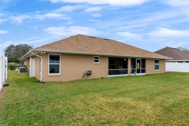 rear view of property with a yard, a sunroom, and central air condition unit