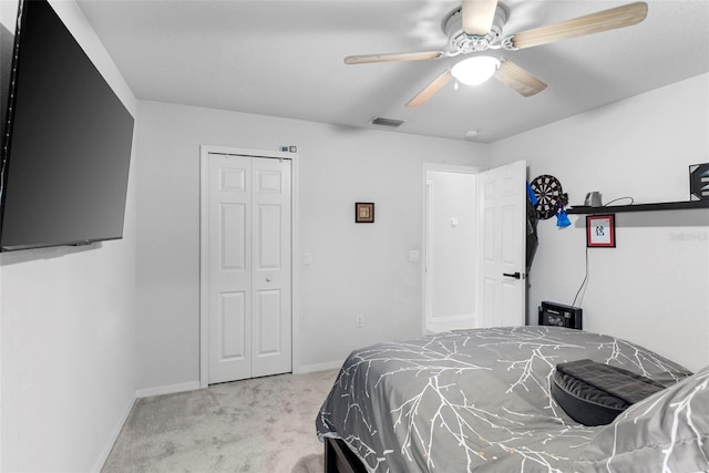 carpeted bedroom featuring ceiling fan and a closet