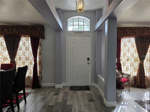 foyer with a high ceiling, a textured ceiling, and hardwood / wood-style flooring