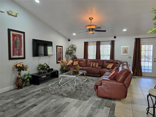 living room featuring ceiling fan, lofted ceiling, and light wood-type flooring