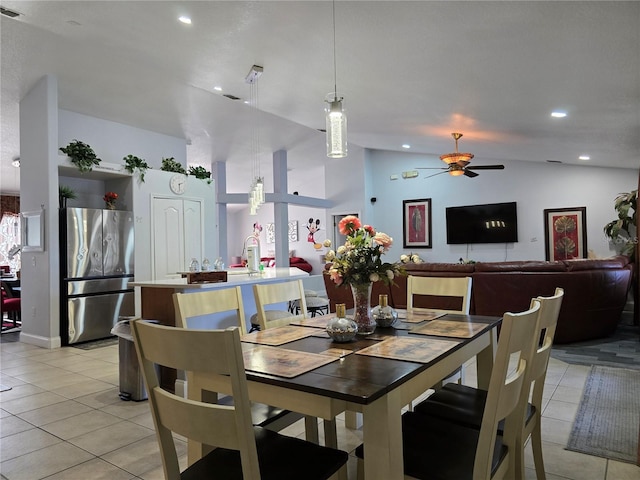 dining space with ceiling fan, light tile patterned floors, and lofted ceiling