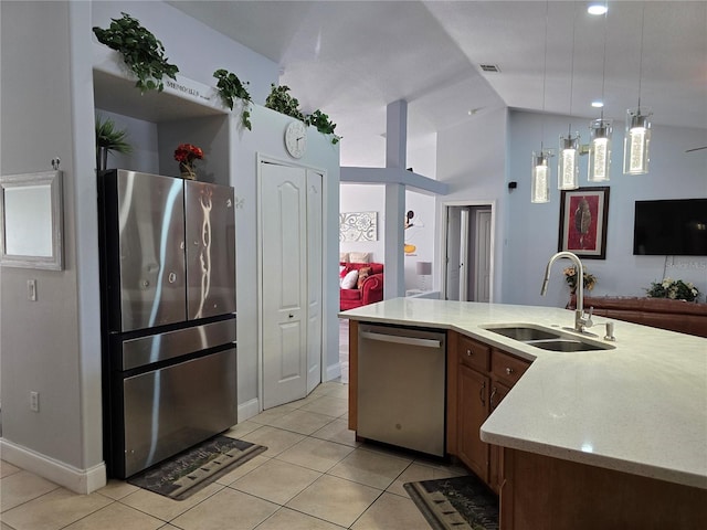 kitchen with light tile patterned flooring, appliances with stainless steel finishes, hanging light fixtures, and sink