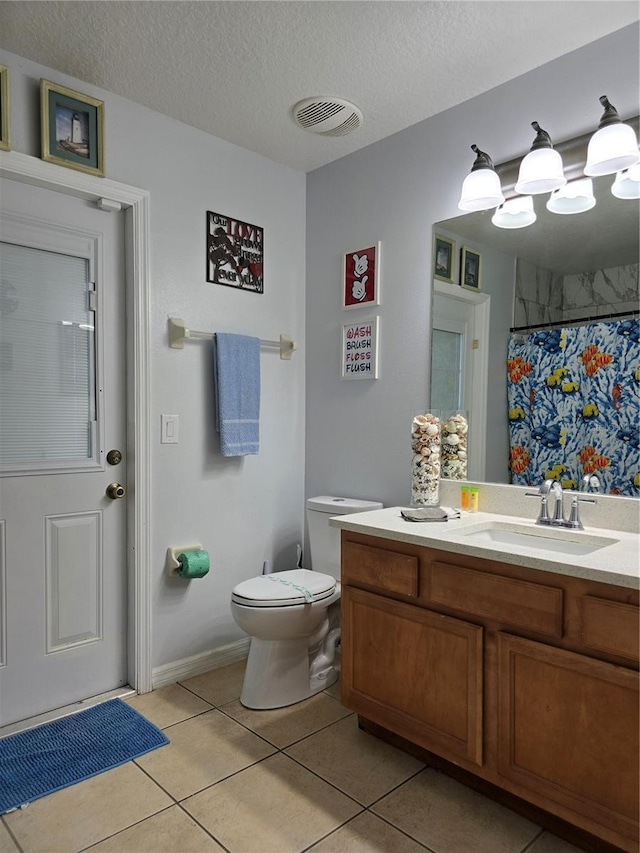 bathroom featuring toilet, tile patterned flooring, walk in shower, a textured ceiling, and vanity