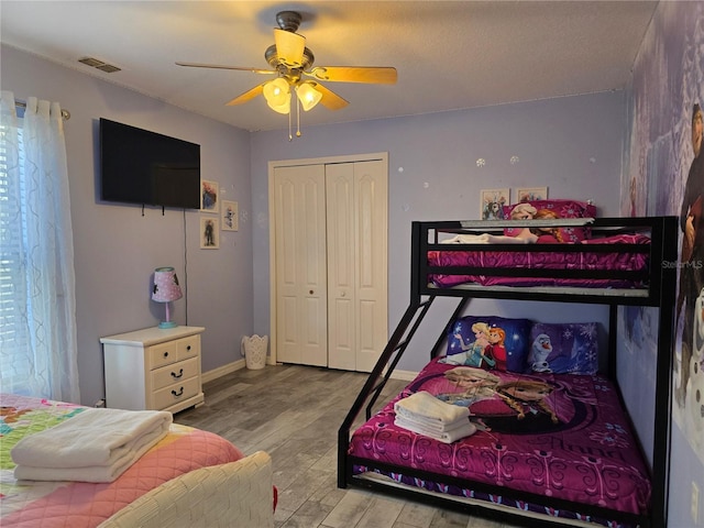 bedroom with light hardwood / wood-style floors, a closet, and ceiling fan