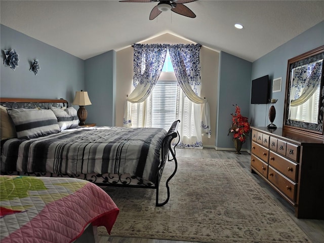 bedroom with ceiling fan, light wood-type flooring, and vaulted ceiling