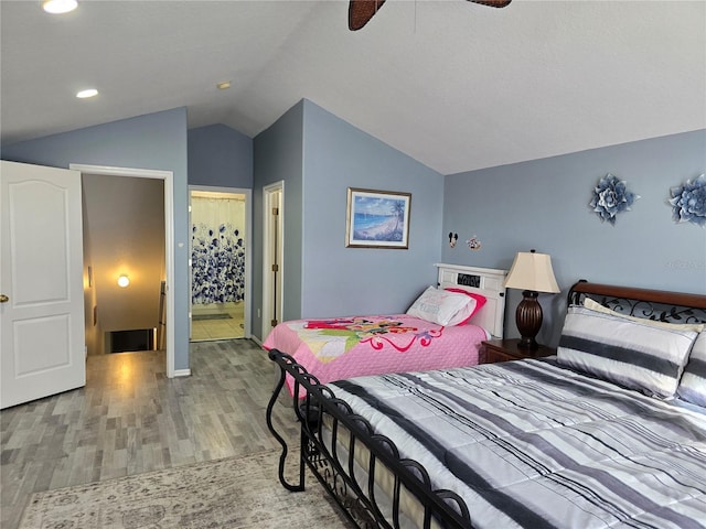 bedroom featuring ceiling fan, light wood-type flooring, and lofted ceiling