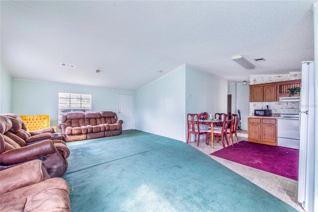 carpeted living room featuring a textured ceiling and vaulted ceiling